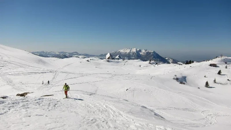 Sciatore con bastoncini vicino a un rifugio